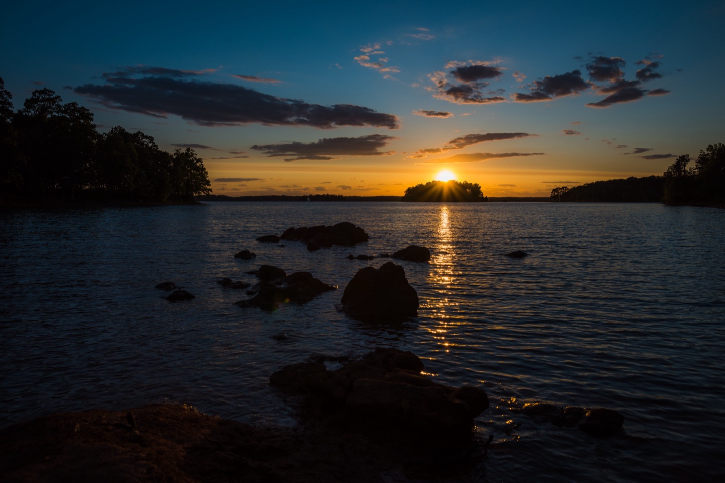 Sunset over Lake Hartwell, the sun on a wooded island horizon throwing a golden path across the water