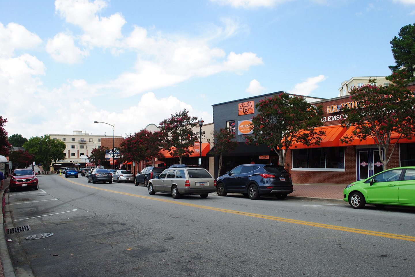 College Avenue in downtown Clemson, orange-awninged storefronts along a tree-lined street