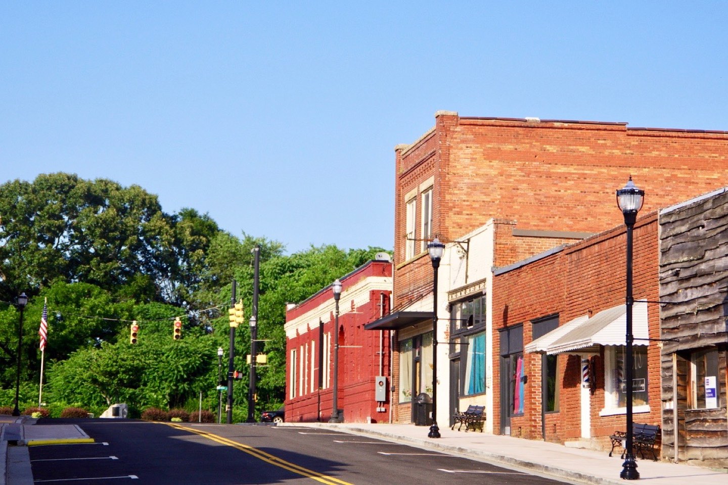 Red brick storefronts with awnings along Mill Street in downtown Inman