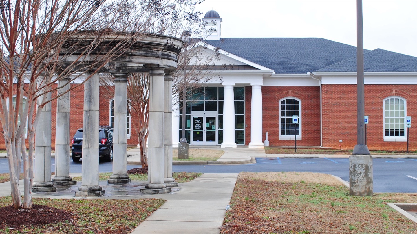 The red brick Powdersville branch library behind a stone colonnade and crepe myrtles