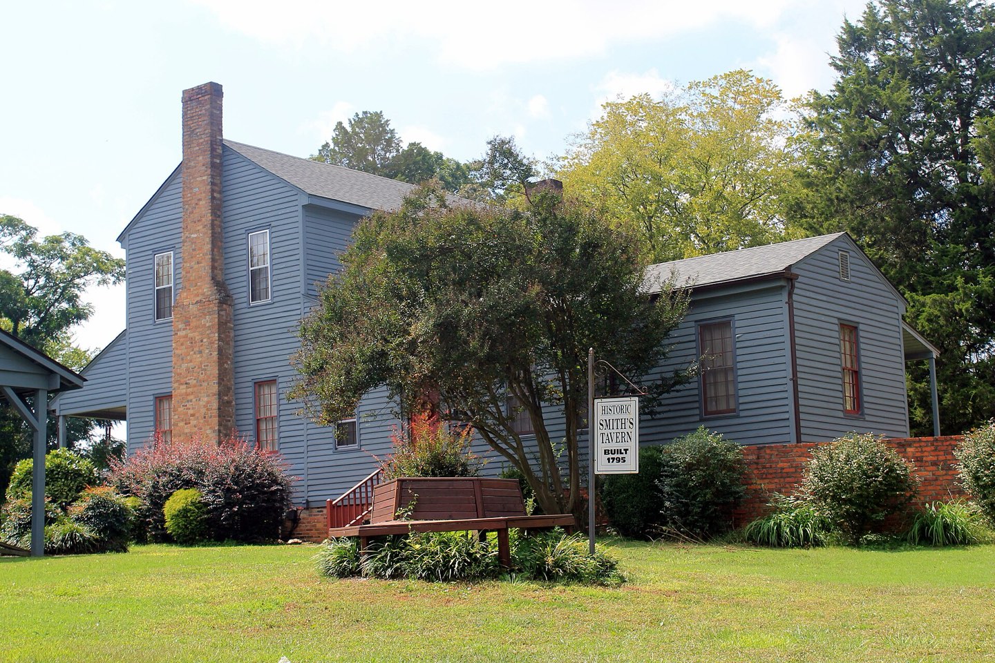Smith's Tavern in Roebuck, an 18th-century clapboard house with brick chimneys behind a lawn and shade trees
